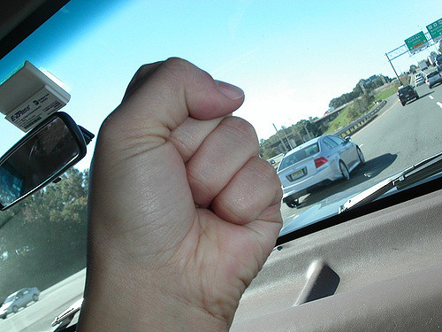 A driver raising a fist while driving.