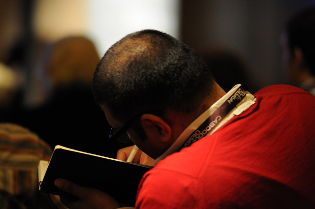 A man writing in a notebook.