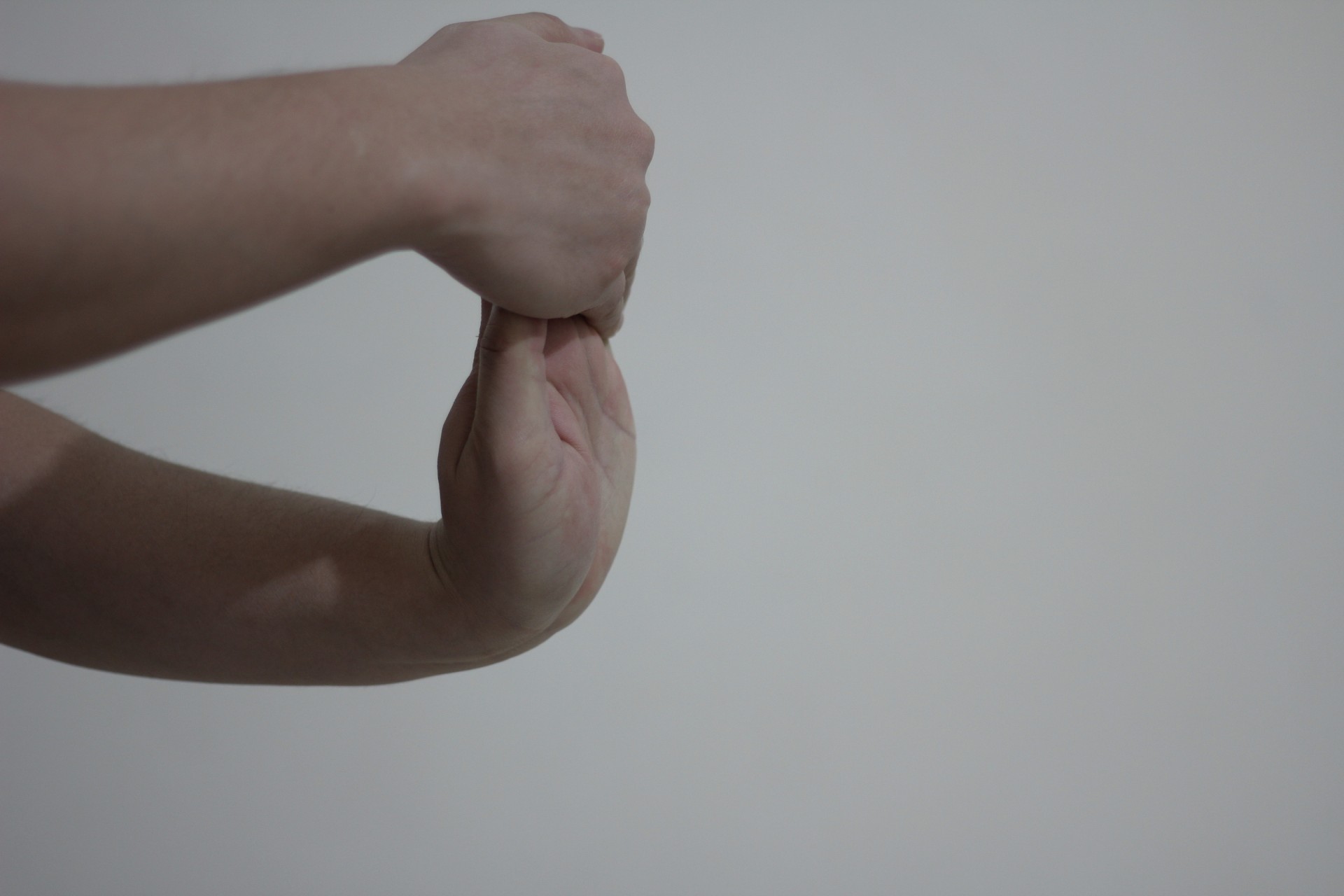One hand stretching the other back toward the body.