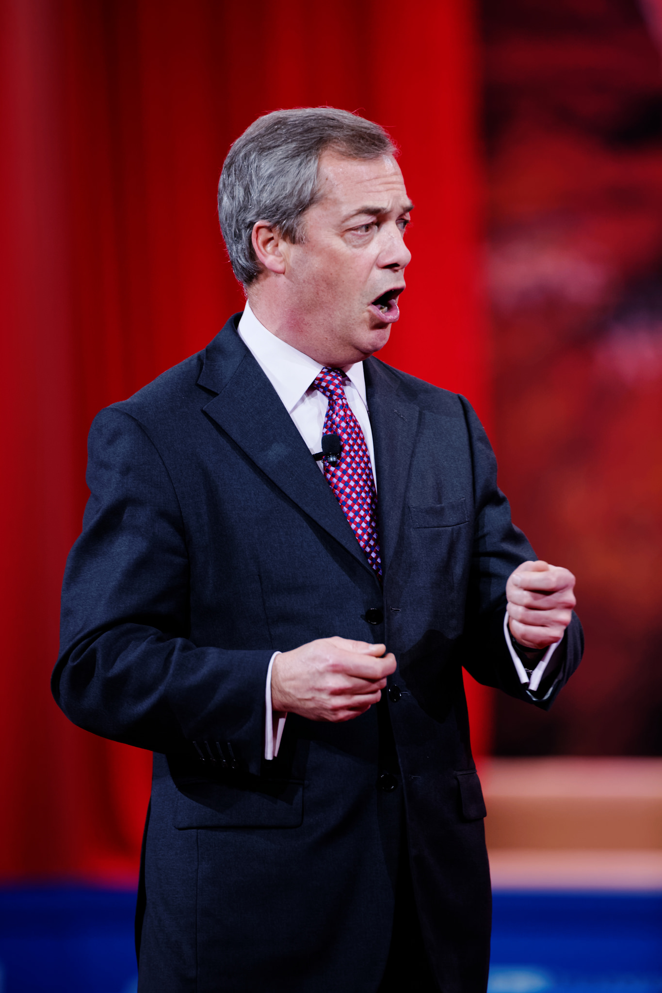 A man in a suite and tie speaking in public.
