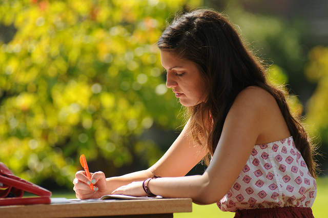 A young woman reading with a highlighter.