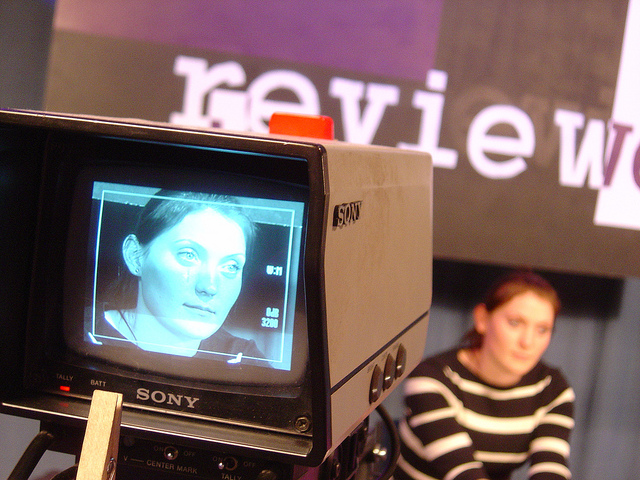 A young woman on camera at a television studio.