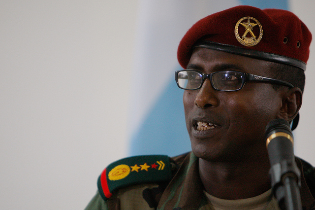 A man wearing a beret and speaking into a microphone.