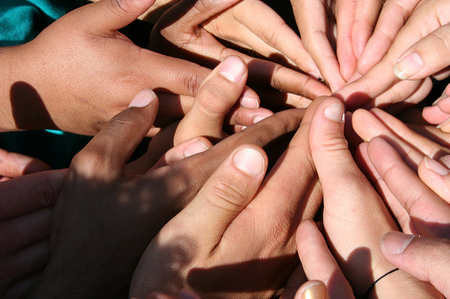 Many hands goining in the center.