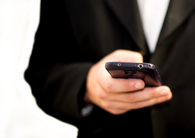 A hand dialing a cell phone.