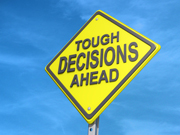 A sign with the words "tough decisions ahead."