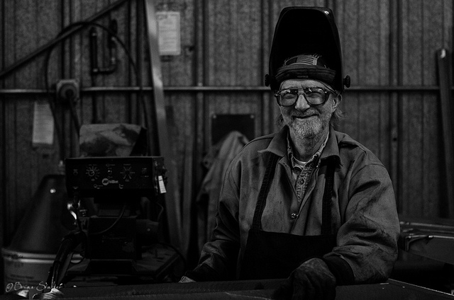 A male welder smiling.