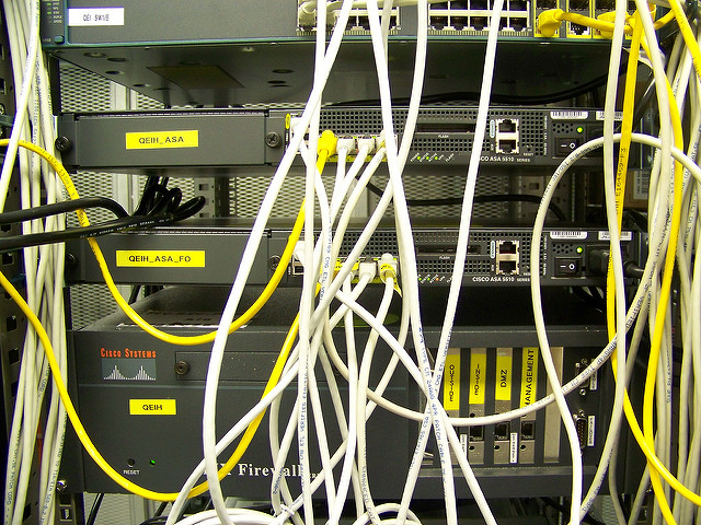 The back of a server rack with many cords, and the word "firewall."