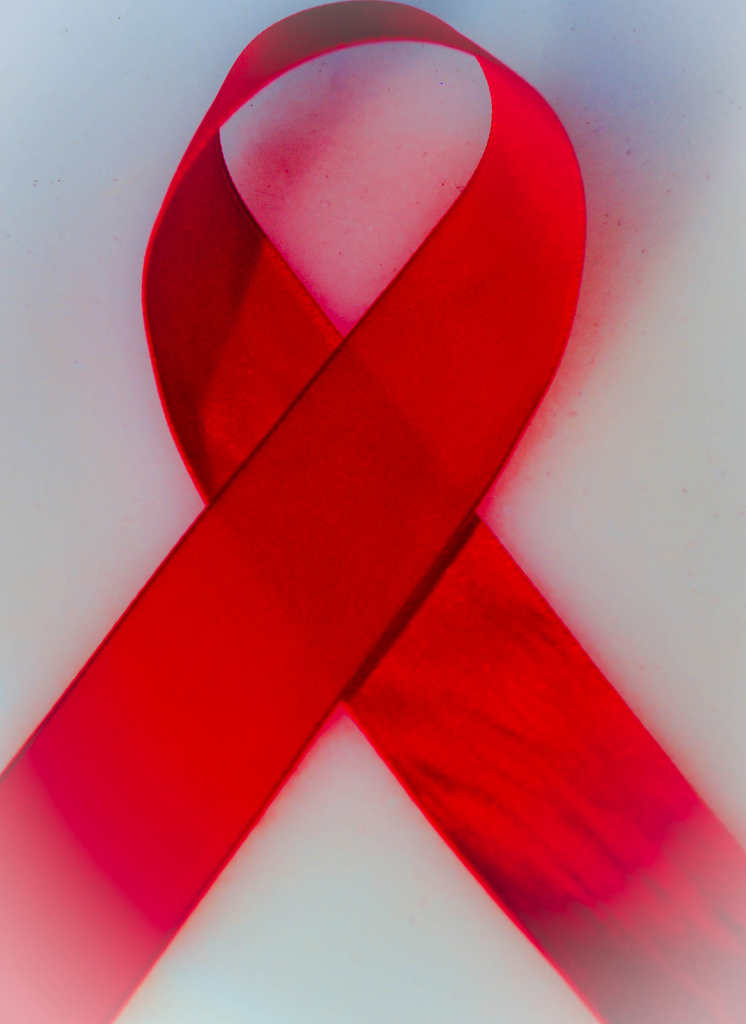 A red HIV and AIDS awareness ribbon.