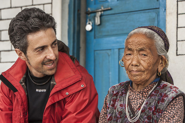 A middle-aged looking man and a woman with wrinkles sitting on doorstep together.