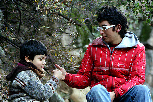 A boy and a young man having a thumb war.