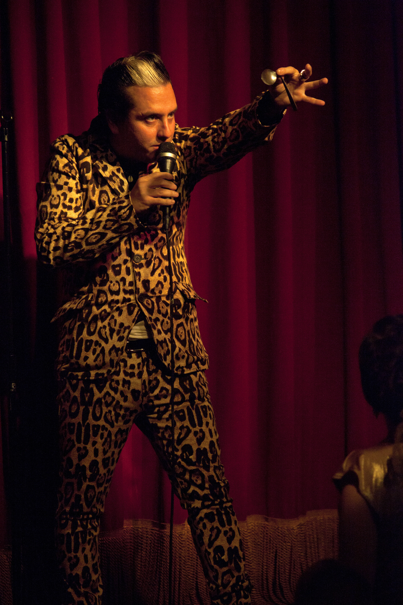 A magician on stage concentrating as if he is reading someone's mind.
