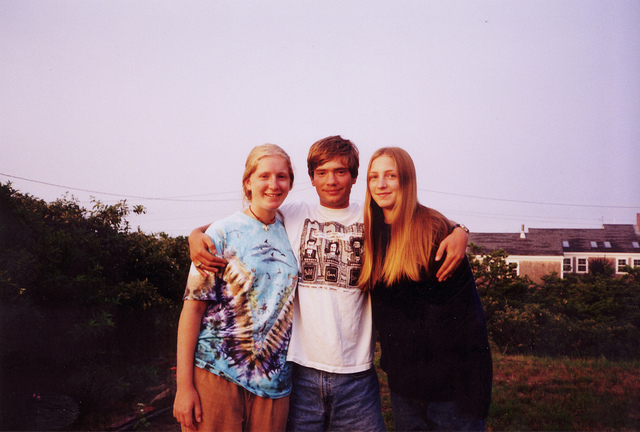 Three close friends, an adolescent boy with his arms around two adolescent girls.