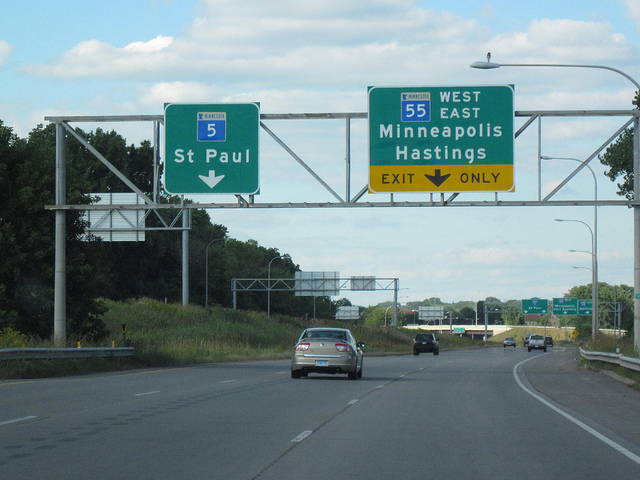 Highway signs with the words "5 Saint Paul" and "55 West East Minneapolis Hastings exit only."